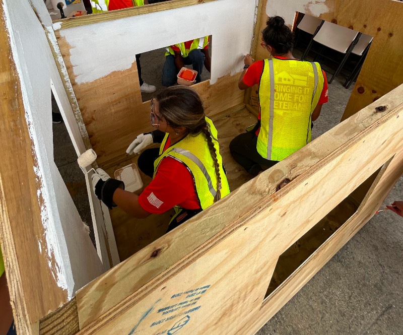 Employees building a playhouse.